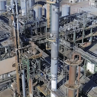 A drone flying over a well-organized orchard or plantation, likely monitoring or mapping tree health and growth.